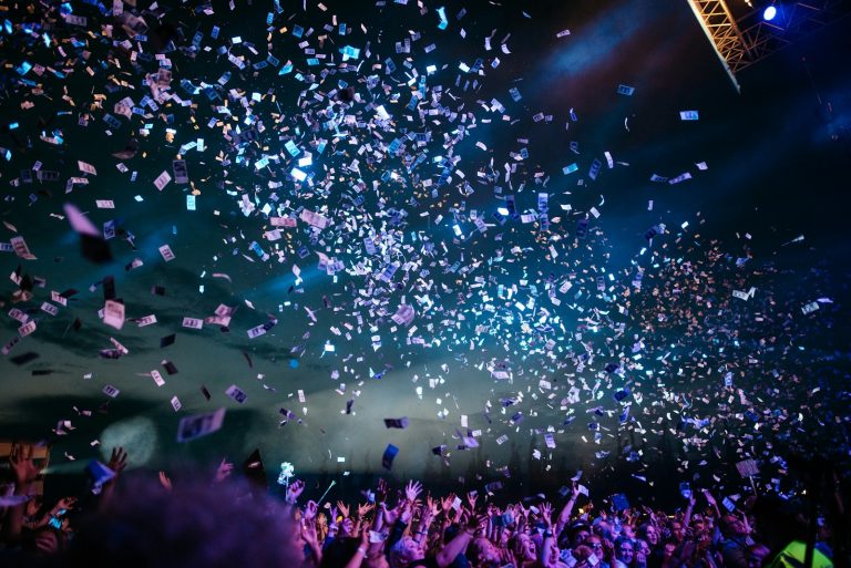 Scene festive avec eclairages colores et confettis pour une soiree d entreprise themee originale
